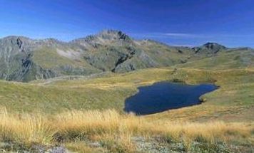 Rolling, grassy hills end in dark mountains.