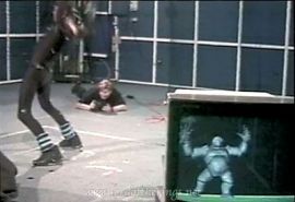 A stuntman in a special suit moves against a tracking grid as a computer recreates the motion with a digital creature.