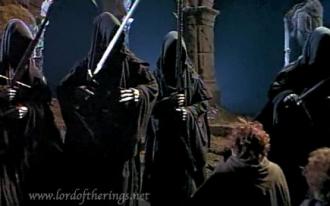 A three-foot hobbit's back faces the man-sized Nazgul.